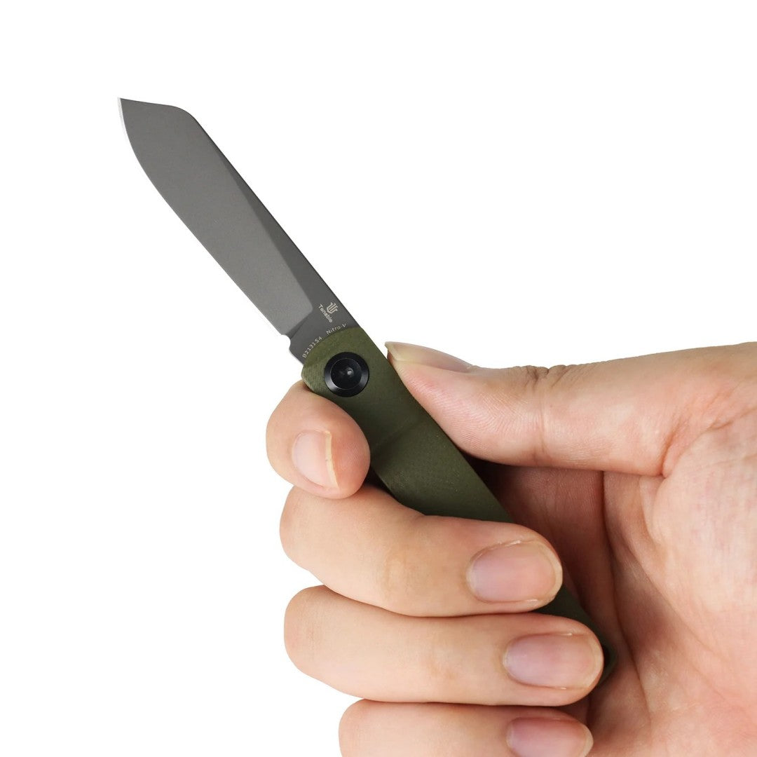 In-hand shot of the open Tenable Riflestock B2131S4 showing ergonomic olive green G10 grip, studio product photo on a white background